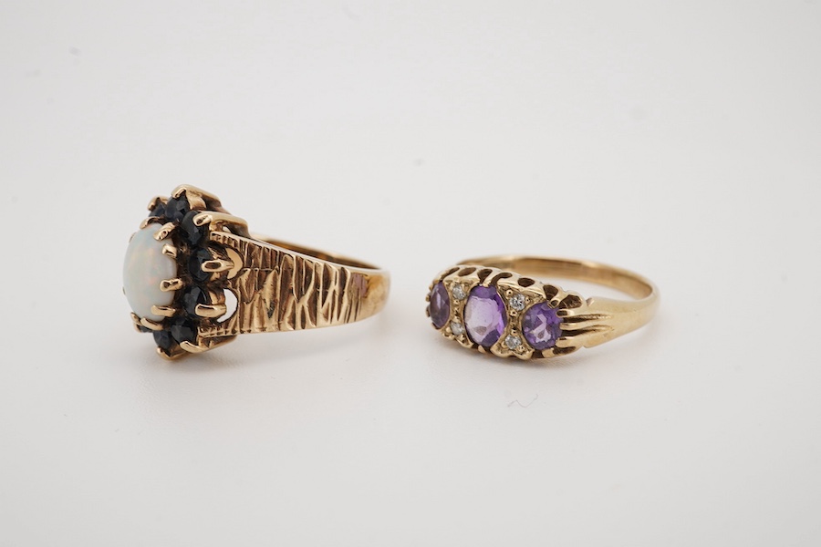 A 1970's textured 9ct gold, white opal and sapphire set oval cluster ring, size L, together with a modern 9ct gold and three stone amethyst set ring, with diamond chip spacers, size M/N, gross weight 7 grams. Condition -